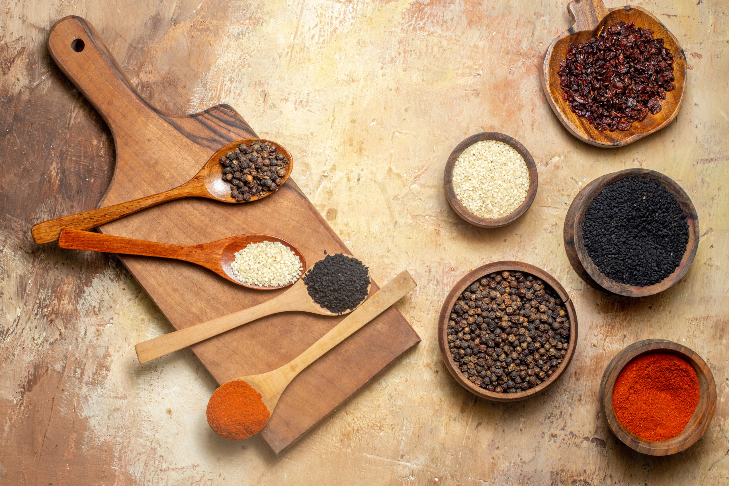 top-view-various-spices-small-brown-pots-cutting-board