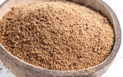 Coconut palm sugar in coconut bowl isolated on white background