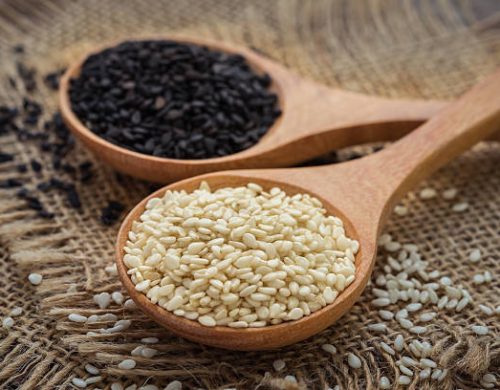 White sesame and black sesame seed on wooden spoon